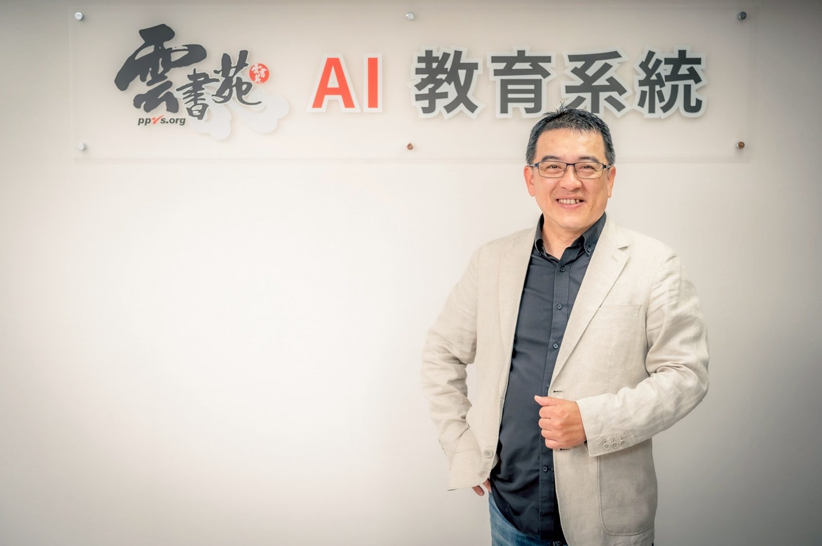 帥爸站在 AI 教育系統的招牌前